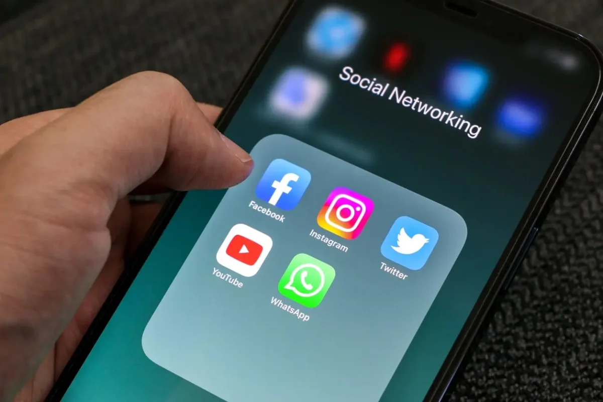 Mano che fa scrolling su uno smartphone su cui si visualizzano varie app social - MGM Systems realizzazione siti web aziendali